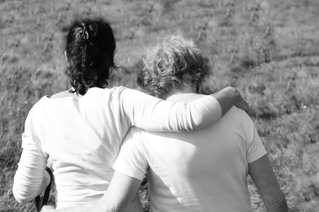 Two women in a field hugging
