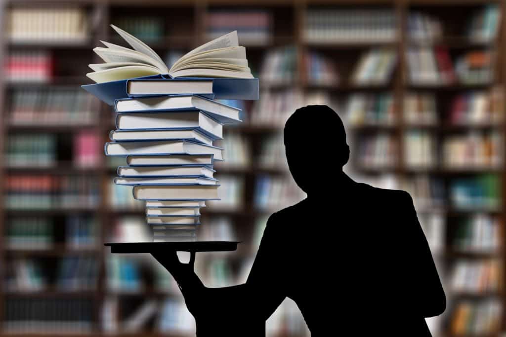 Dictionary of marketing terms - stack of books and silhouette of man representing a stack of marketing terms
